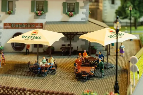 FALLER H0 Biergarten-Set Veltins - Detailliertes Biergarten-Set für H0 Modelleisenbahnen, ideal zur Gestaltung lebendiger Szenen in Ihrer Modellwelt. Perfekt für Sammler und Modellbau-Enthusiasten.