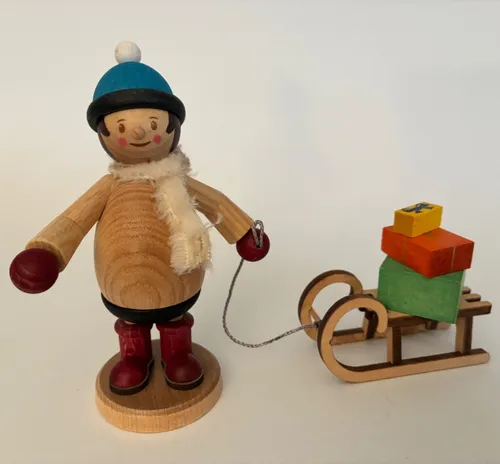 Mäxchen mit Geschenkschlitten - Erzgebirgische Holzkunst Figur, handgefertigt und ideal als liebevolles Geschenk oder Dekoration für die Weihnachtszeit.