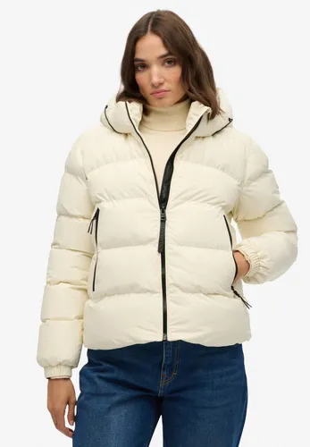 Superdry Damen W5011996A Stanton Off-White Steppjacke mit Kapuze - Die lässige Steppjacke für Damen bietet einen stylishen Schutz gegen Kälte. Mit praktischen Taschen und verstellbarem Saum ist sie ideal für aktive Tage und sorgt für Komfort und Funktionalität.