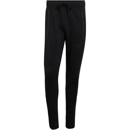 Adidas Tiro Travel Sweathose - Schwarz - Die Adidas Tiro Travel Sweathose vereint Komfort und Stil. Mit atmungsaktivem Material und praktischen Reißverschlusstaschen ist sie ideal für Fußballfans und den Alltag. Der mittelhohe Bund und Beinreißverschlüsse bieten optimale Passform und Flexibilität.
