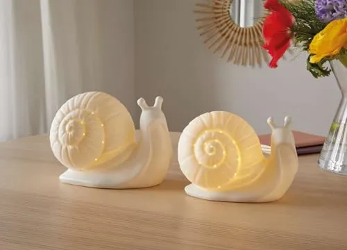 Dekoleidenschaft 2X Dekofigur Schnecke aus Porzellan mit LED Beleuchtung - Statuen - Set aus 2 LED-Schnecken in elegantem Weiß. Mit dekorativen Ausstanzungen für tollen Leuchteffekt. Ideal für stimmungsvolle Akzente im Innenbereich.