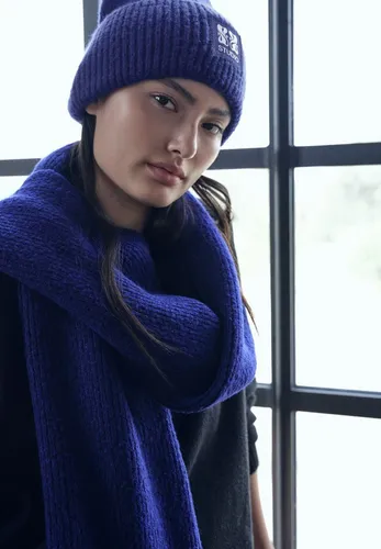 Damen Beanie mit Badge - Strickmütze für Damen, weich und kuschelig mit Badge-Detail, ideal für kalte Tage und angenehmen Tragekomfort.