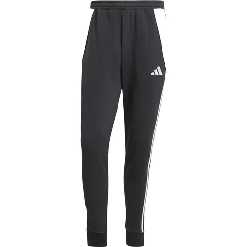Adidas TIRO 24 JOGGINGHOSE - schwarz - Trainingshose aus weichem Material mit flauschiger Innenseite, ideal für entspannte Momente nach dem Fußball. Mit Rippbündchen und praktischen Reißverschlusstaschen für unbeschwerten Komfort.