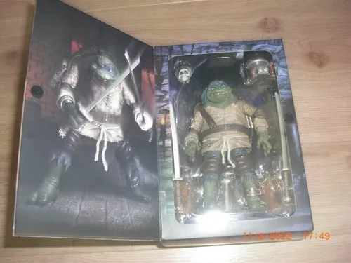 NECA Michelangelo Mummy Moderne Actionfigur - Spielfigur von NECA, 18 cm groß und detailreich gestaltet. Ideal für Sammler und Fans der TMNT-Serie, inklusive Zubehör wie Katana und Hände.